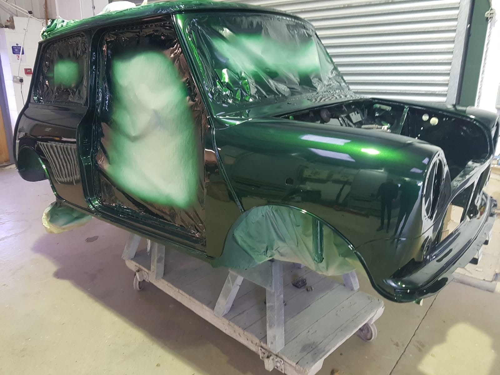 Mini body shell in fresh deep green metallic paint, still masked up in the spray booth